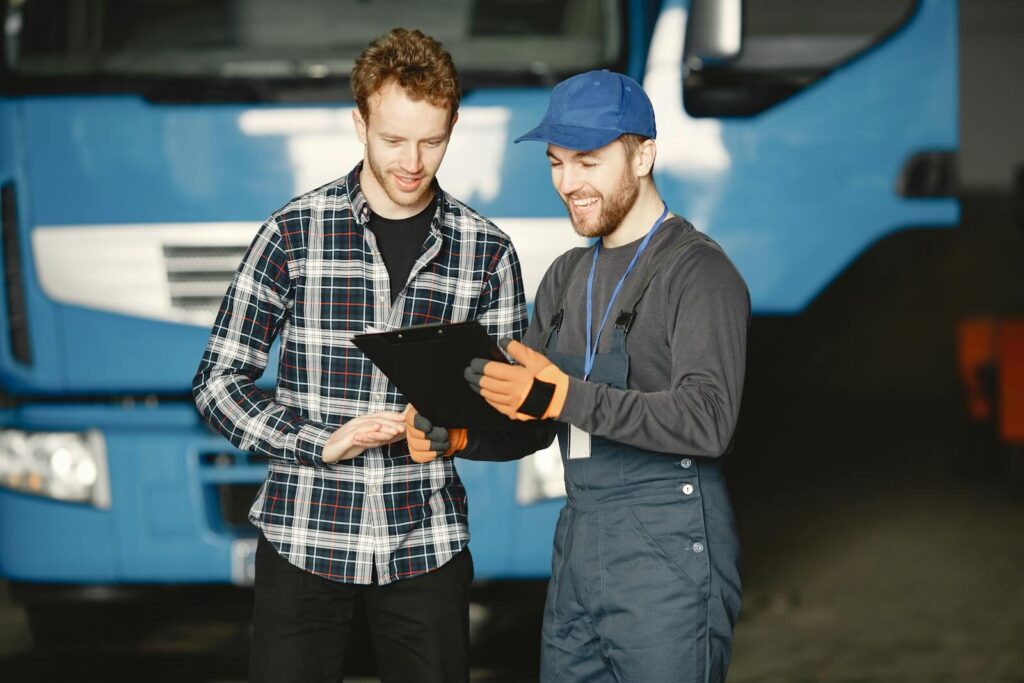 Transport Manager discussing truck repairs in a garage.